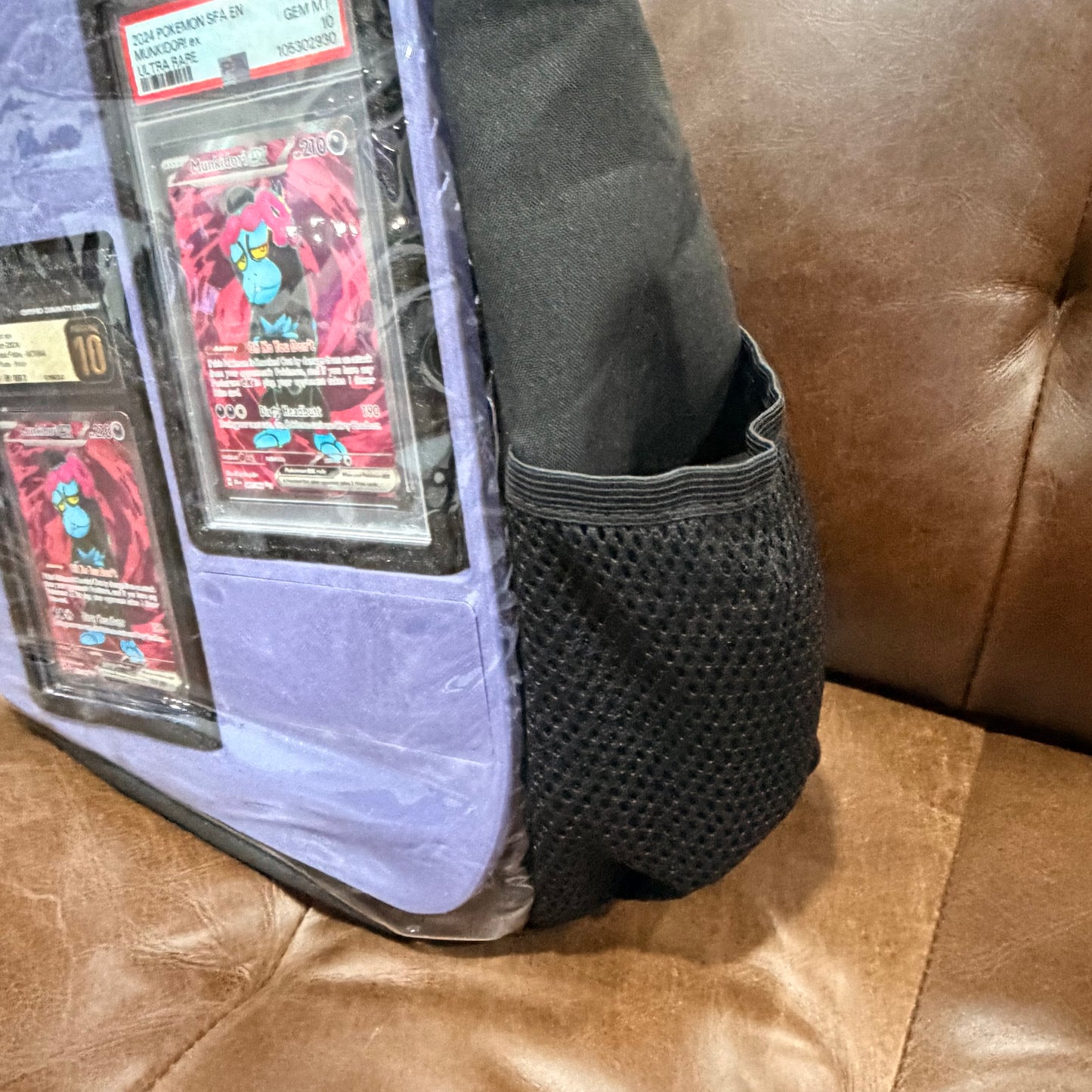 Side view showing mesh pocket on black crossbody bag with light blue insert
